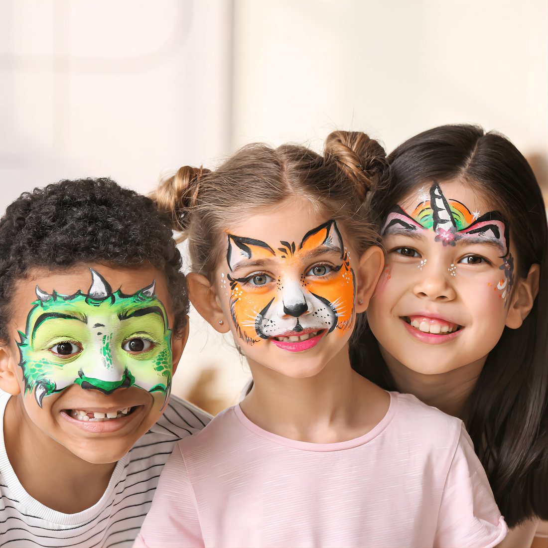 Three children with dinosaur, tiger and unicorn face paint drawn with ThEast markers